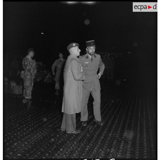 Le chef de bataillon Jean Souquet, chef du 3e bureau de l'état-major de la 10e DP (division parachutiste) discute avec un capitaine avant l'embarquement des soldats.