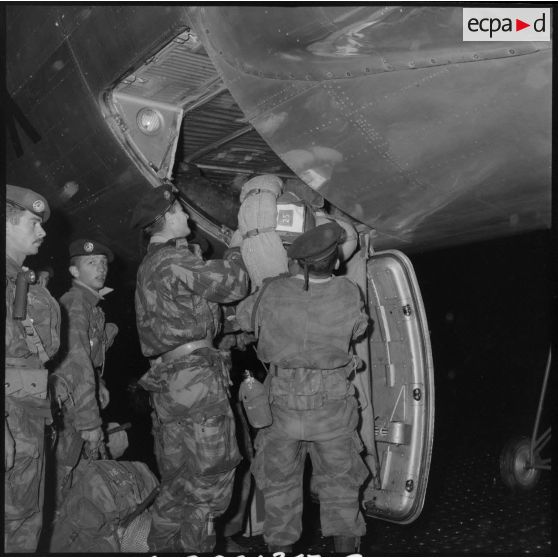 Les soldats du 2e régiment de parachutistes coloniaux (RPC) disposent leurs paquetages dans la soute de l'avion.