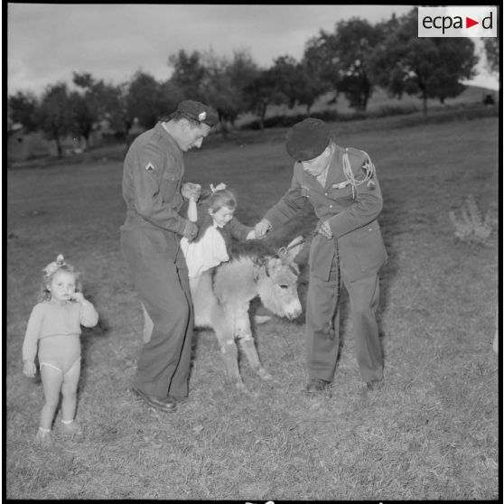Le sergent Chébila et le caporal-chef Jannicaud jouent avec les enfants de Hamma Plaisance.