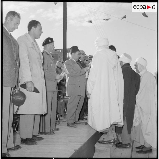Le capitaine Fuchs écoute un discours sur la tribune officielle.