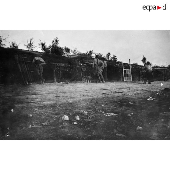[Soldats en attente à côté de cellules à pièces d'artillerie, s.d.]