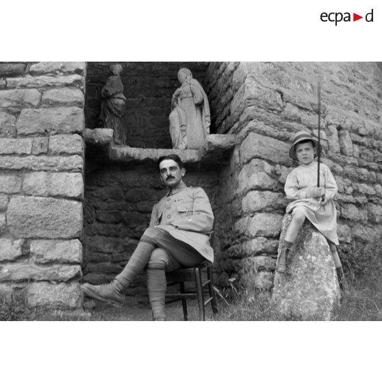 [Jean Gélas pose avec un enfant devant un muret, s.d.]