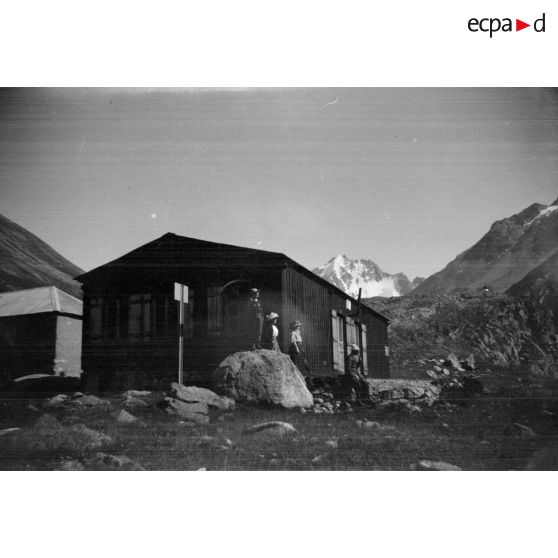 [Promeneurs stationnant devant un abri de montagne].