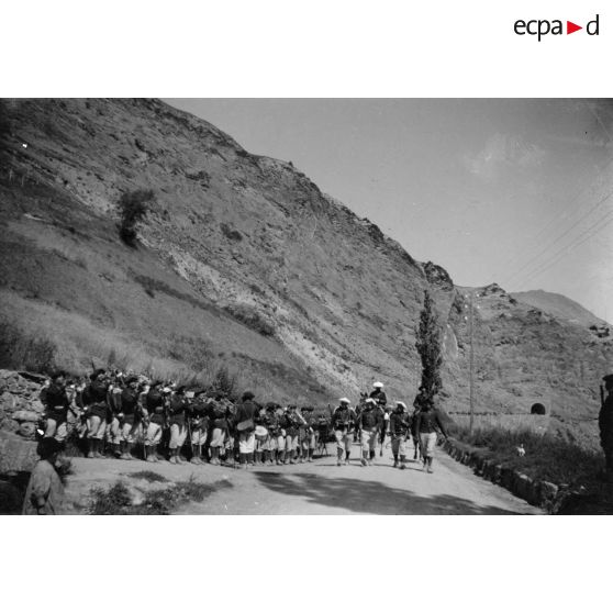 [Défilé d'un régiment de chasseurs alpins sur une route de montagne].