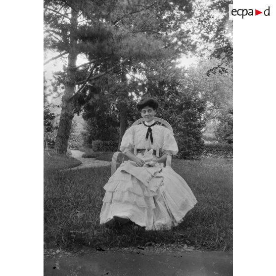 [Portrait de femme en robe blanche en extérieur, s.d.]