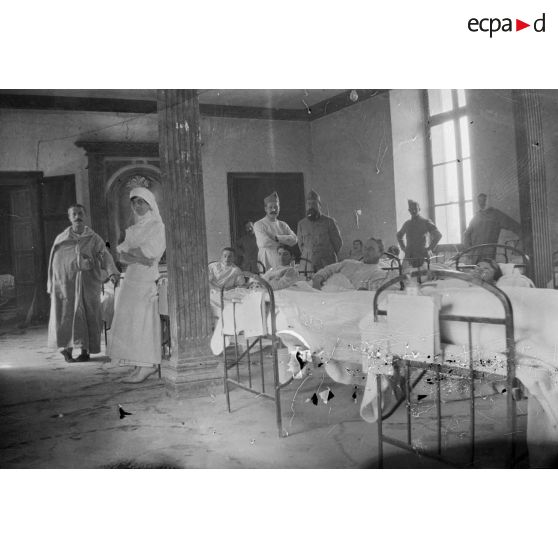 [Personnel du service de santé posant aux côtés de blessés dans un hôpital de campagne, s.d.]