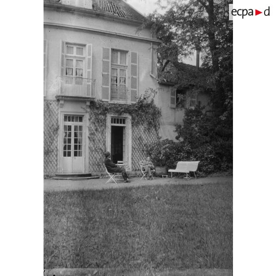 [Deux hommes assis à l'extérieur d'une maison, s.d.]