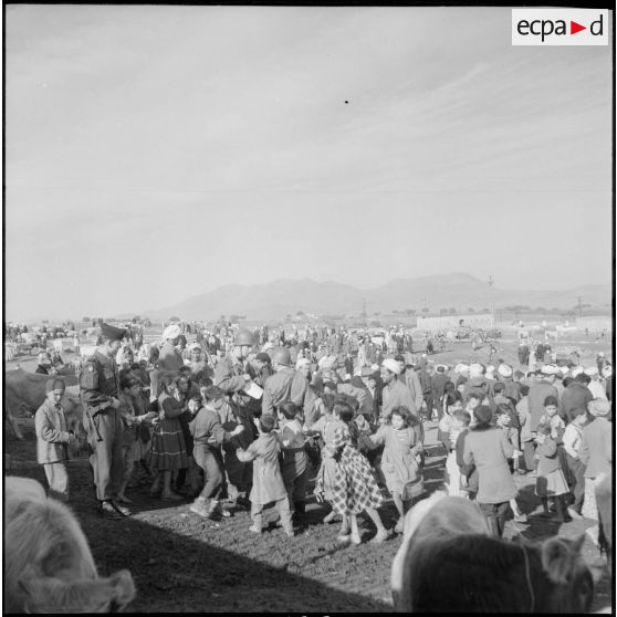 Des officiers de la compagnie de haut-parleurs et de tracts (CPHT) avec des civils de la commune de Guelma, dans le cadre de l'action psychologique.