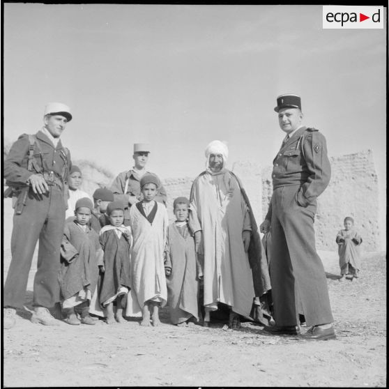 Le lieutenant d'Arbonmont accompagné d'officiers de l'opération de recherche d'Adjoul-Adjoul, du bachaga et d'enfants de Zeribet El Oued.