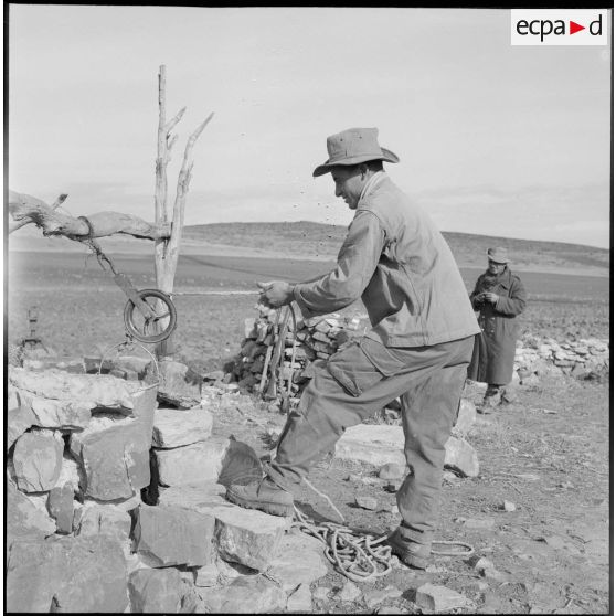 Un tirailleur du 9e BTA (bataillon de tirailleur algérien) tire l'eau d'un puit lors de sa mission de protection d'un champ.