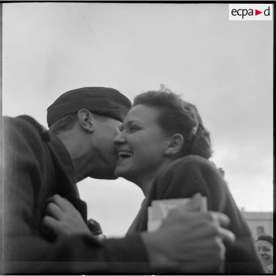 Un caporal embrasse une jeune femme sur le port de Bône avant d'embarquer à bord du Président de Cazalet.