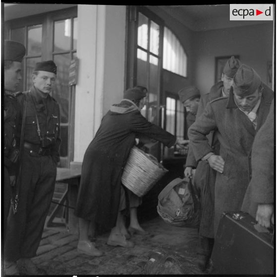 Des appelés du contingent ayant terminé leurs services militaires, bagages en main, arrivent au port d'Oran afin d'embarquer à bord du Ville d'Oran.