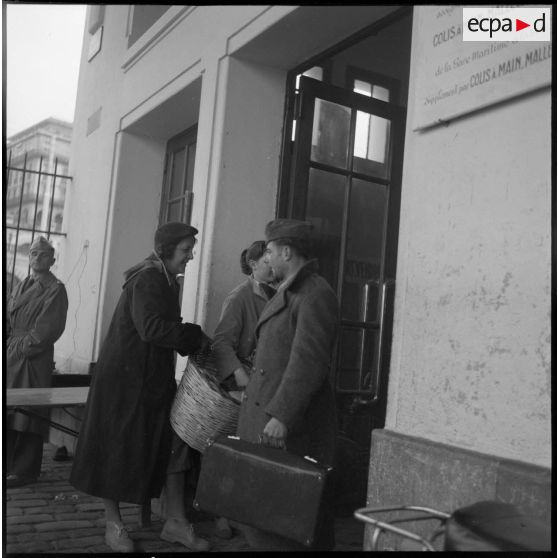 Des femmes distribuent des vivres aux appelés ayant terminé leurs services militaires au port d'Oran.