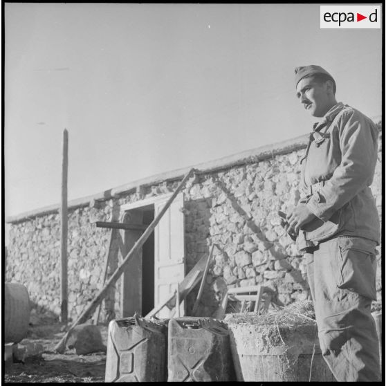 Un soldat sur un chantier devant une mechta en ruine.