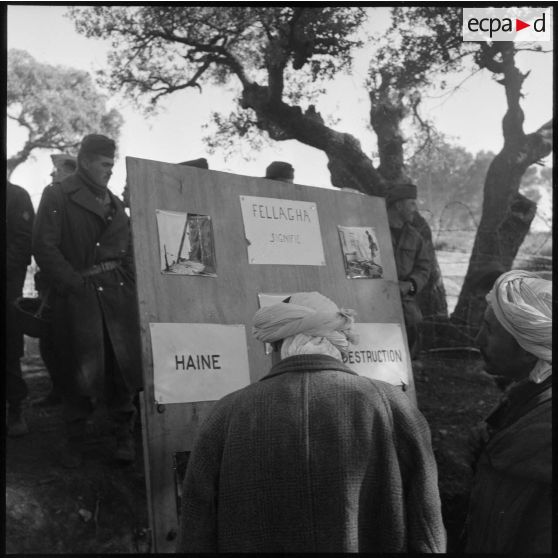 Panneau photographique présenté par une compagnie de haut-parleurs et de tract (CHPT) devant la population masculine algérienne d'un village.