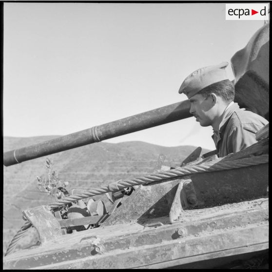 Portrait d'un soldat du 2e régiment de spahi algérien (RSA) posté devant une mitrailleuse sur un char léger dans le djebel algérien.