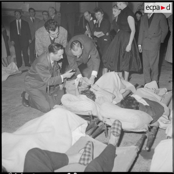 Distribution de boîtes d'allumettes par le présentateur André Leclerc aux soldats blessés de l'hôpital Maillot d'Alger.