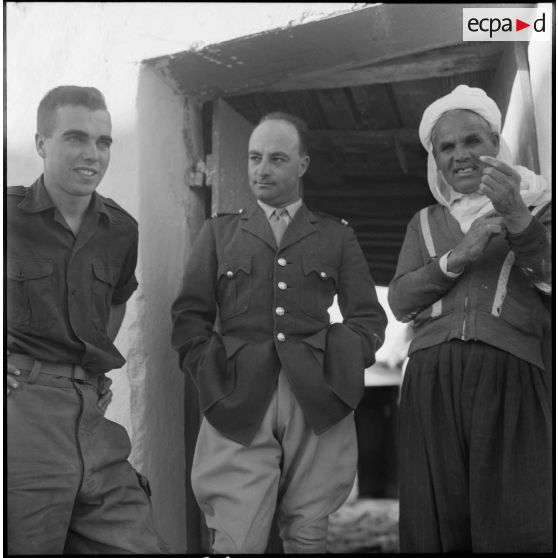 Deux militaires posant avec un villageois.