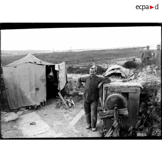 Place de l'Opéra, près de Souain, Marne, ouvrier mécanicien devant sa tente. [légende d'origine]