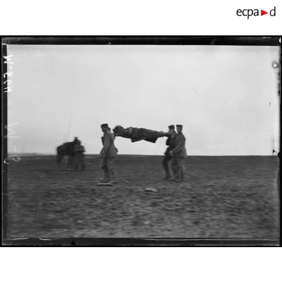 Au nord de Souain, des prisonniers allemands portent un blessé. [légende d'origine]