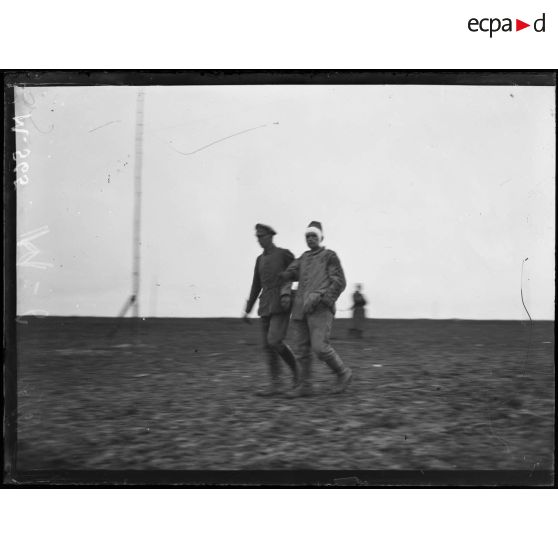 Au nord de Souain, des prisonniers allemands blessés se portent mutuellement pour être évacués vers l'arrière du front. [légende d'origine]