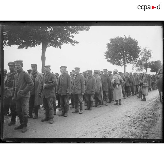 Des prisonniers allemands capturés lors de l'offensive de Champagne attendent sur la route de Souain. [légende d'origine]