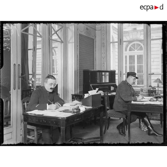 Monsieur Hélies et son secrétaire, responsable du service des ouvriers du Sous-secrétariat d'Etat aux munitions. [légende d'origine]