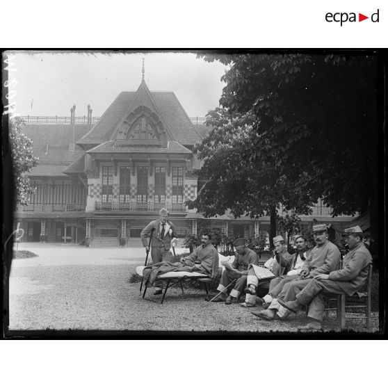 Hôpital militaire canadien de Saint-Cloud, blessés au repos sur la terrasse devant le tableau d'affichage. [légende d'origine]