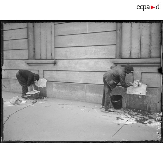Paris, bombardement par canon. Rue Manin, maçons bouchant des soupiraux. [légende d'origine]