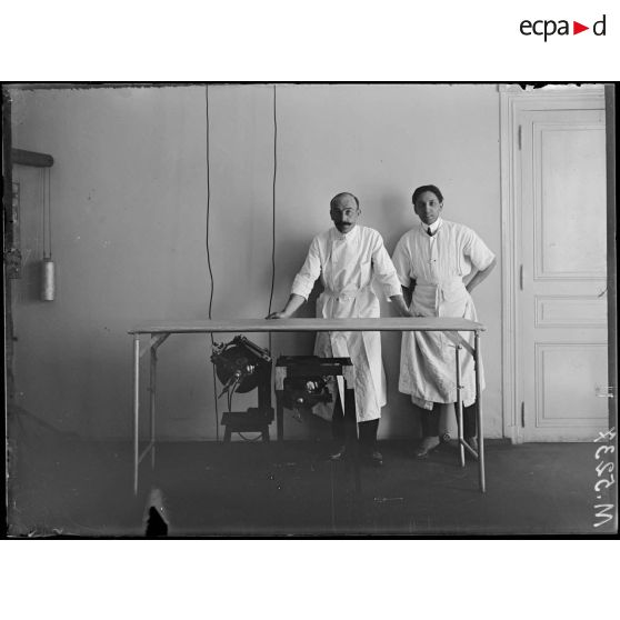 Paris, hôpital franco-brésilien, de la Pompe. Le médecin chef M. Rio de Branco et un des ses aides dans la salle de radiographie. [légende d'origine]