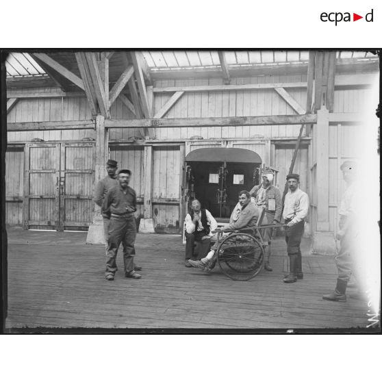 Paris, gare d'évacuation de la Chapelle. Blessé amené dans un fauteuil roulant près à être monté dans l'auto ambulance. [légende d'origine]
