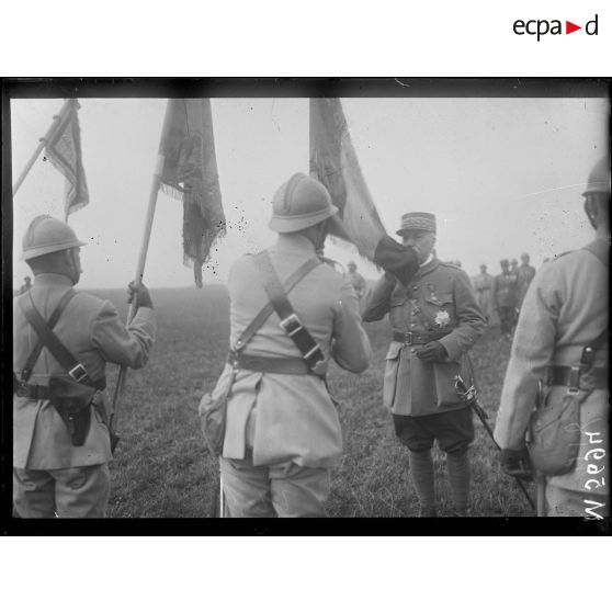 Cerceuil, remise de fourragère par le général de Castelnau. Le général embrasse le drapeau du 155e d'infanterie qu'il vient de décorer de la fourragère jaune. [légende d'origine]