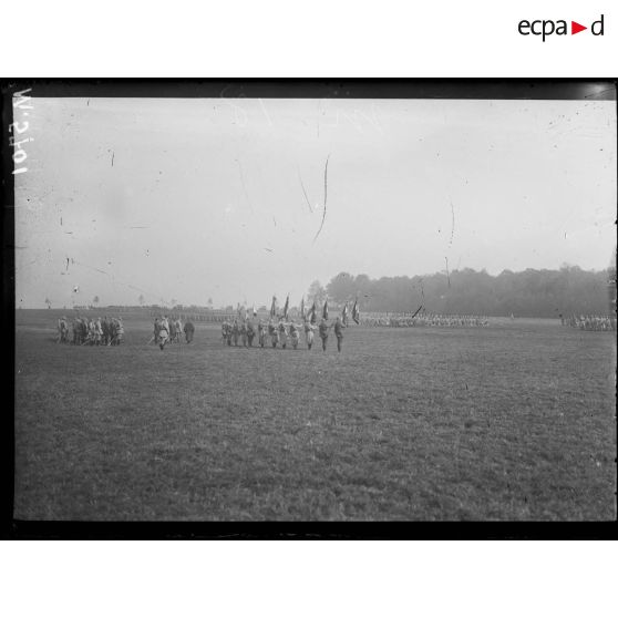 Cerceuil, remise de fourragère par le général de Castelnau. Les troupes représentant les onze régiments cités défilent devant les drapeaux décorés et le général de Castelnau. [légende d'origine]