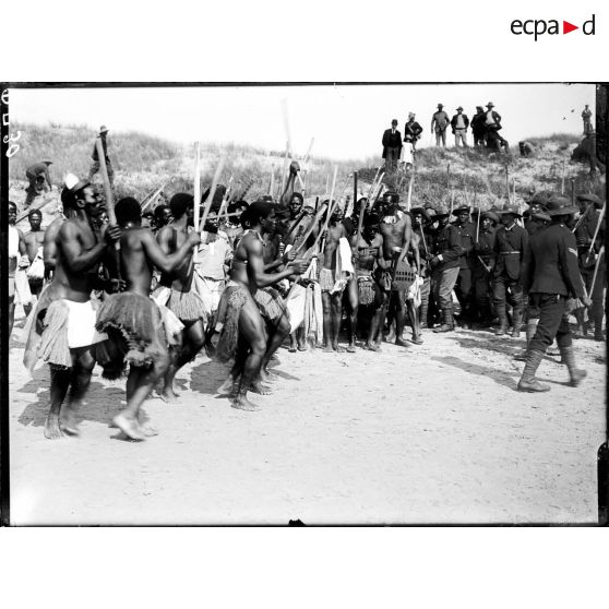 South African Labour Compagny gives a war dance leaving in the arena. Thse people returned to their village and found their housse and garden after great difficulty. [légende d'origine ]<br>[Compagnie de travailleurs sud-africains exécutant une danse guerrière.]