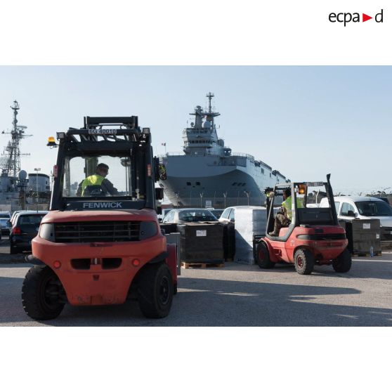 Des soldats du 519e régiment du train (RT) chargent des palettes au moyen de chariots élévateurs Fenwick sur le quai de la base navale de Toulon.