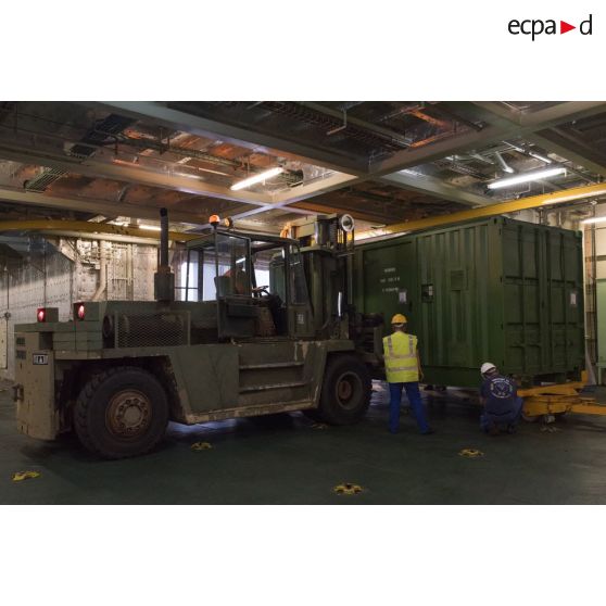 Un chariot Valmet du 519e régiment du train (RT) charge un container à bord du bâtiment de projection et de commandement (BPC) Le Tonnerre à Toulon.