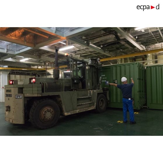 Un chariot Valmet du 519e régiment du train (RT) charge un container à bord du bâtiment de projection et de commandement (BPC) Le Tonnerre à Toulon.