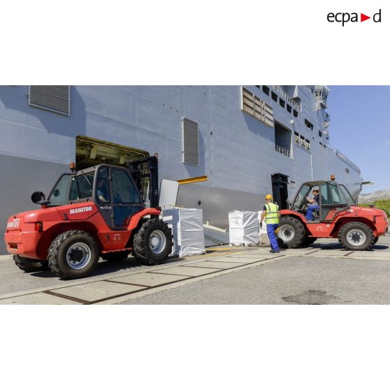 Des soldats du 519e régiment du train (RT) chargent des palettes au moyen de chariots élévateurs Manitou à bord du bâtiment de projection et de commandement (BPC) Le Tonnerre sur la base navale de Toulon.