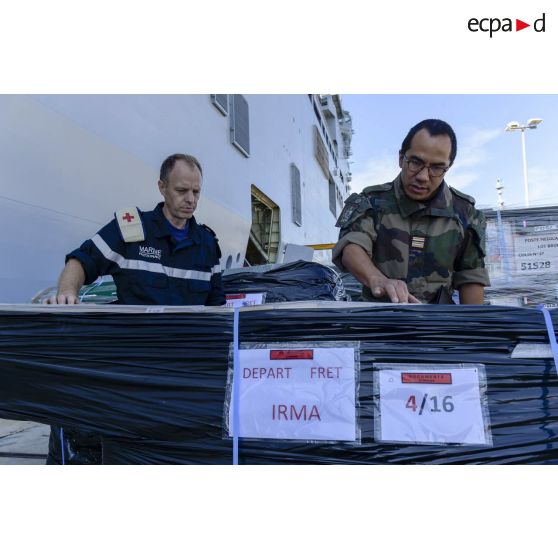 Un chirurgien-dentiste en chef secondé d'un major prend en compte le matériel médical à charger à bord du bâtiment de projection et de commandement (BPC) Le Tonnerre  à Toulon.