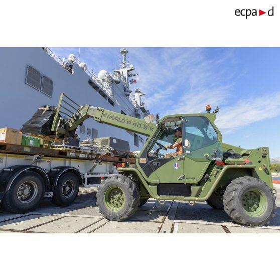 Un soldat du 519e régiment du train (RT) déplace des palettes pour les charger à bord du bâtiment de projection et de commandement (BPC) au moyen d'un chariot Merlo sur la base navale de Toulon.