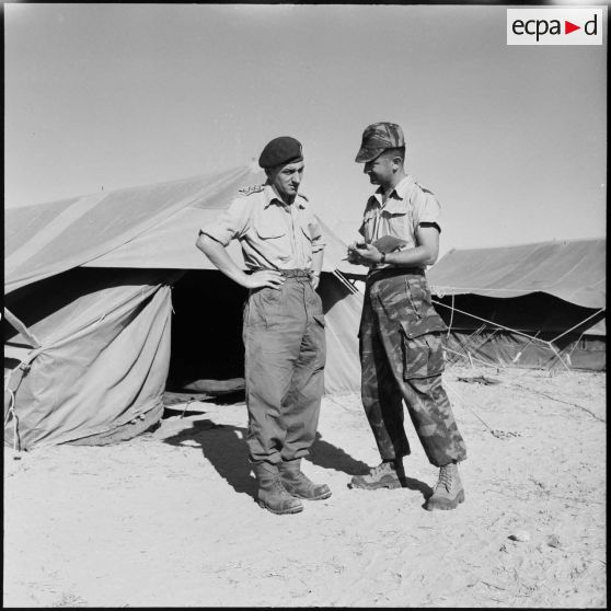 Le capitaine Griffiths de la 6e brigade de parachutistes anglais s'entretient avec le capitaine André Guillaume du 2e RPC au camp X (Chypre).