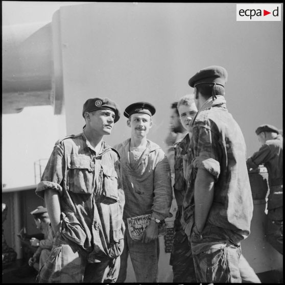 Un matelot du cuirassé Jean Bart donne des explications sur les différentes pièces d'artillerie du bord aux légionnaires du 1er REP.