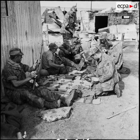 Les parachutistes français du groupement Ouest entretiennent leur armement à Port-Saïd.
