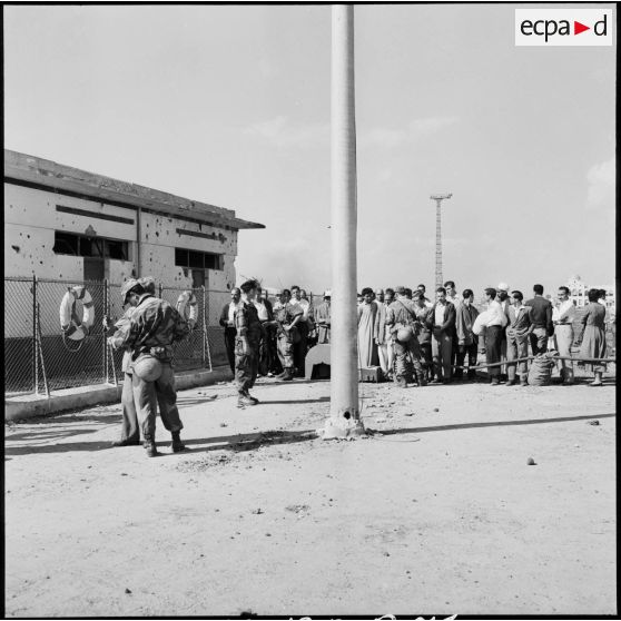 Un contrôle d'identité par les parachutistes français sur le quai du ferry assurant la traversée du canal de Suez.