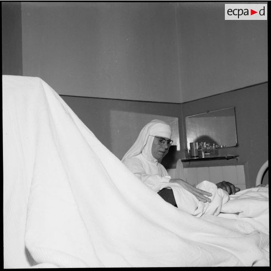 Une religieuse française soigne un civil égyptien blessé lors des bombardements, à la clinique Notre-Dame de la Délivrande à Port-Saïd.