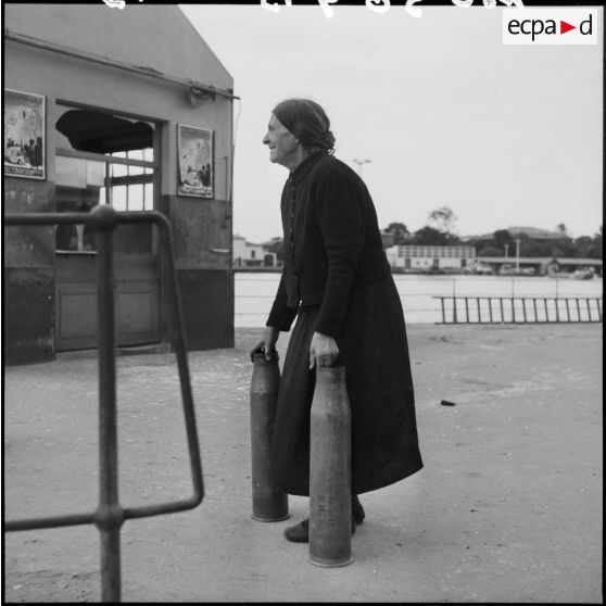 Une vieille femme récupère des douilles d'obus à Port-Fouad.