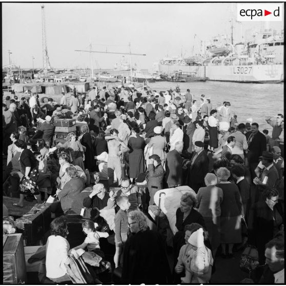 Les ressortissants italiens, grecs et yougoslaves patientent sur le quai avant leur embarquement sur le navire-hôpital Ascania.