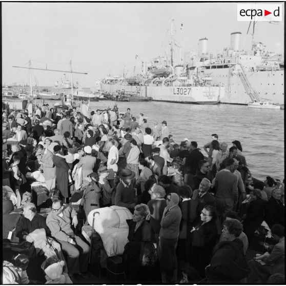 Les ressortissants italiens, grecs et yougoslaves patientent sur le quai avant leur embarquement sur le navire-hôpital Ascania.