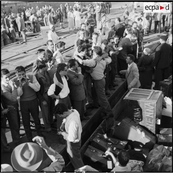 Les ressortissants italiens, grecs et yougoslaves patientent sur le quai avant leur embarquement sur le navire-hôpital Ascania.