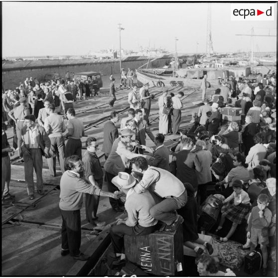 Les ressortissants italiens, grecs et yougoslaves patientent sur le quai avant leur embarquement sur le navire-hôpital Ascania.